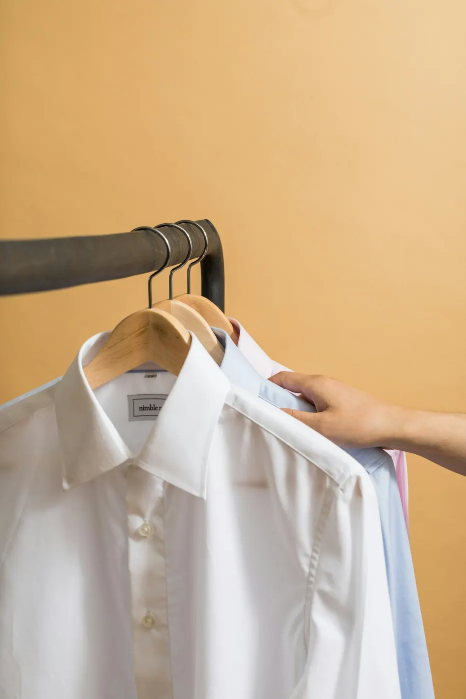 Crisp white shirt on a wooden hanger